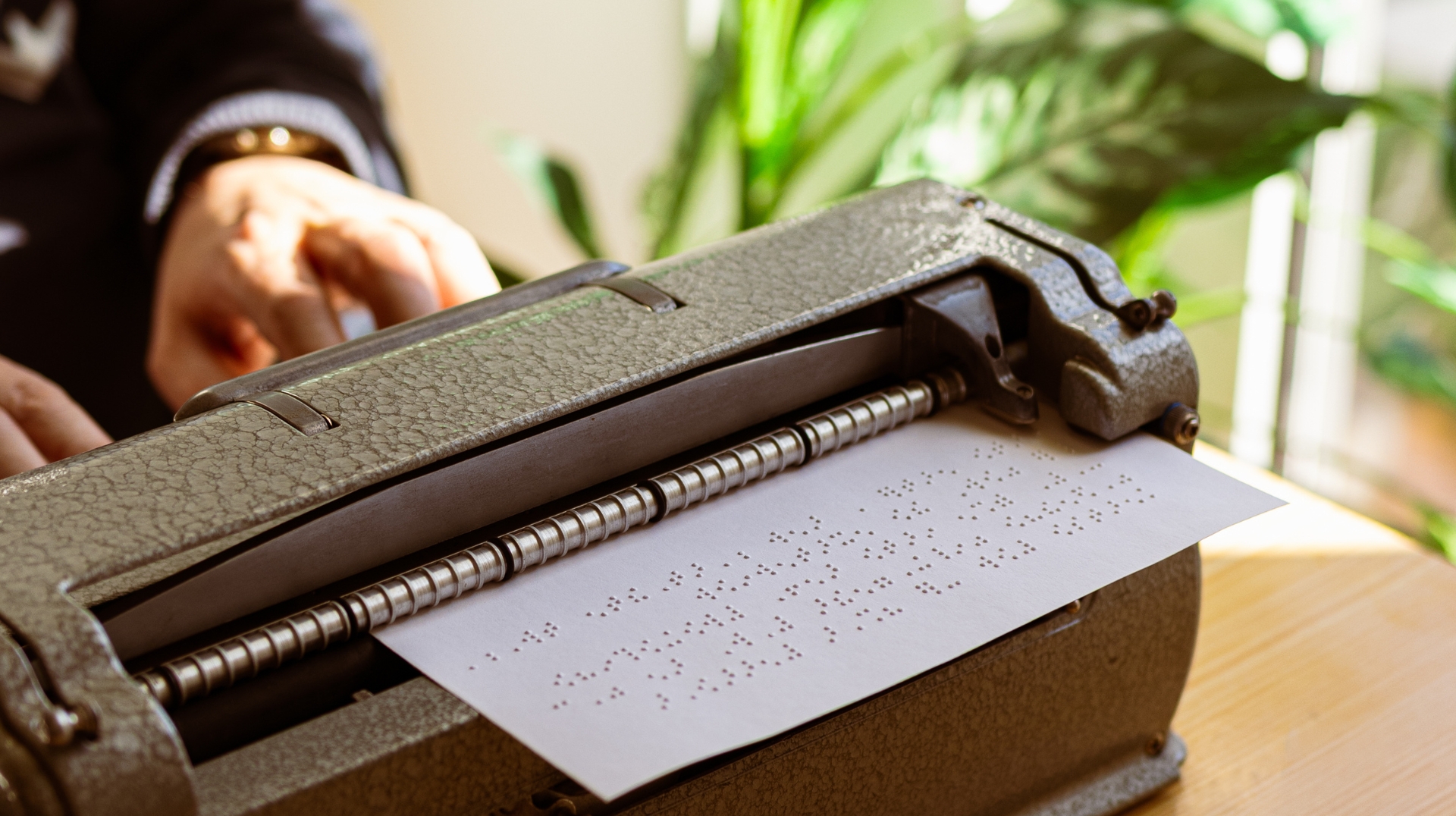 Professor de Braille a escrever numa máquina de Braille