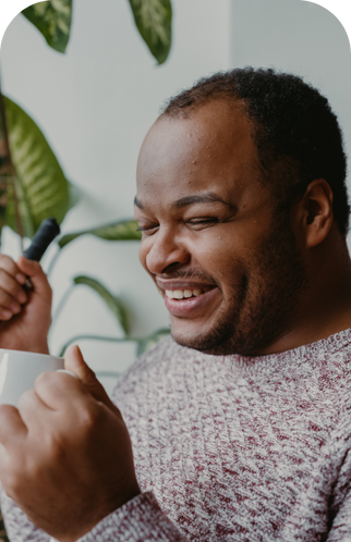 Pessoa cega a beber um chá e a segurar uma bengala
